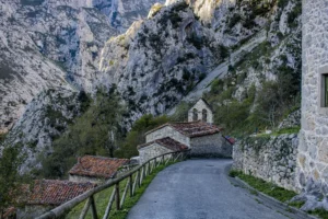 Iglesia de San Pedro en la parte baja de la carretera con la montaña de fondo.