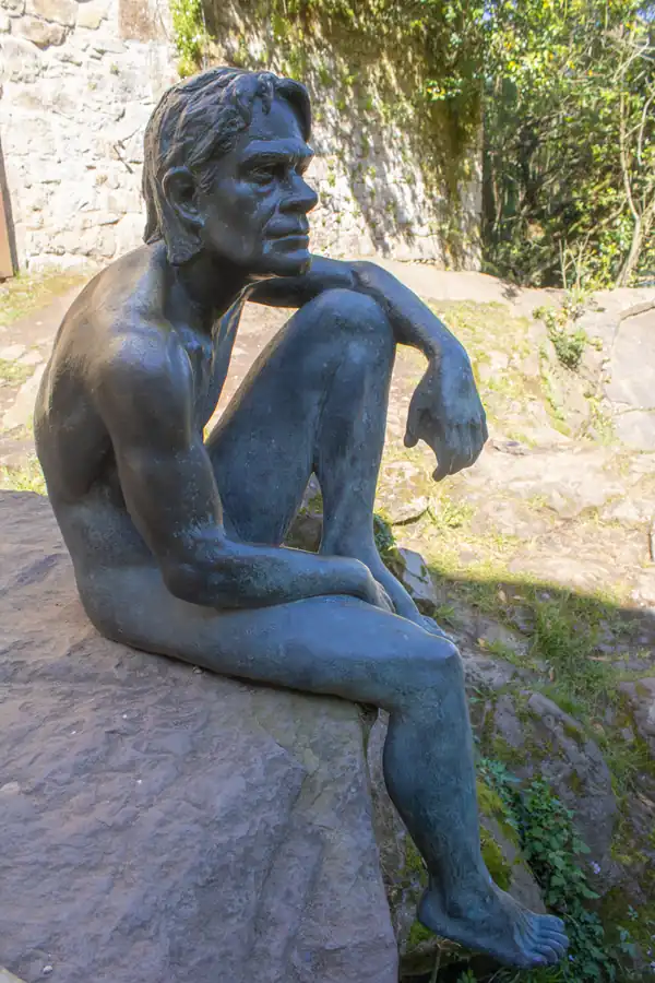 Estatua del Hombre pez sentado en una roca