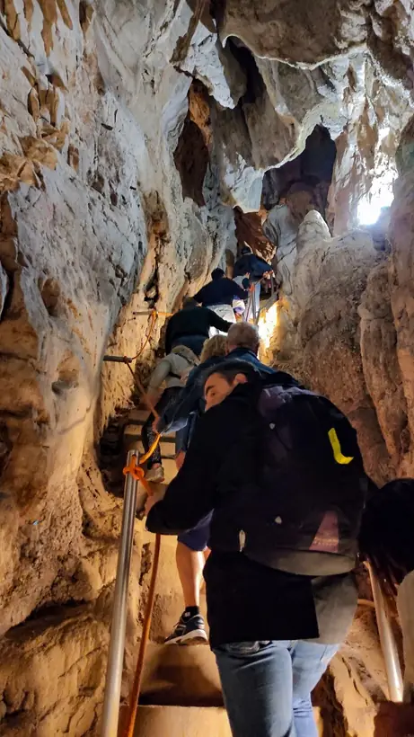 Varias personas subiendo las escaleras del tramo final de la cueva de las Güixas